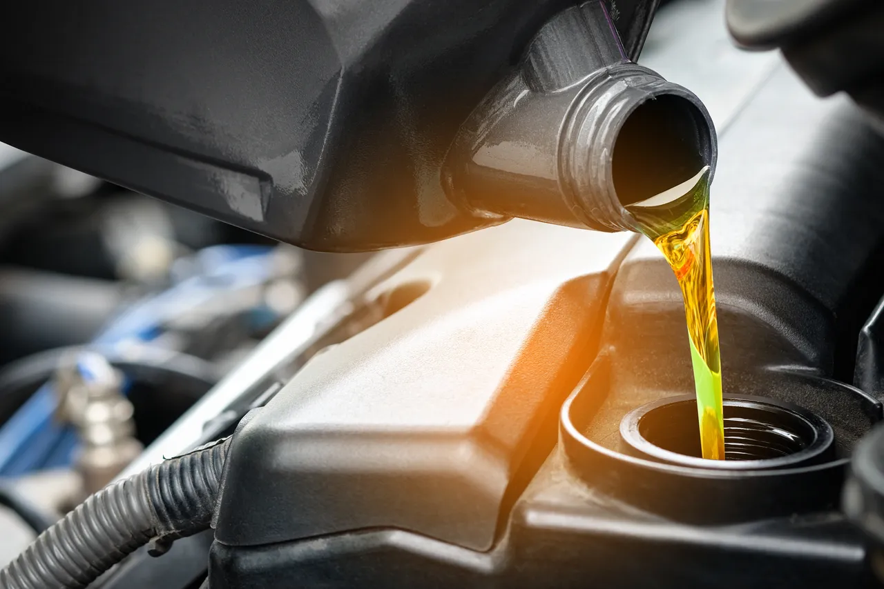 Engine oil being poured during a precision service