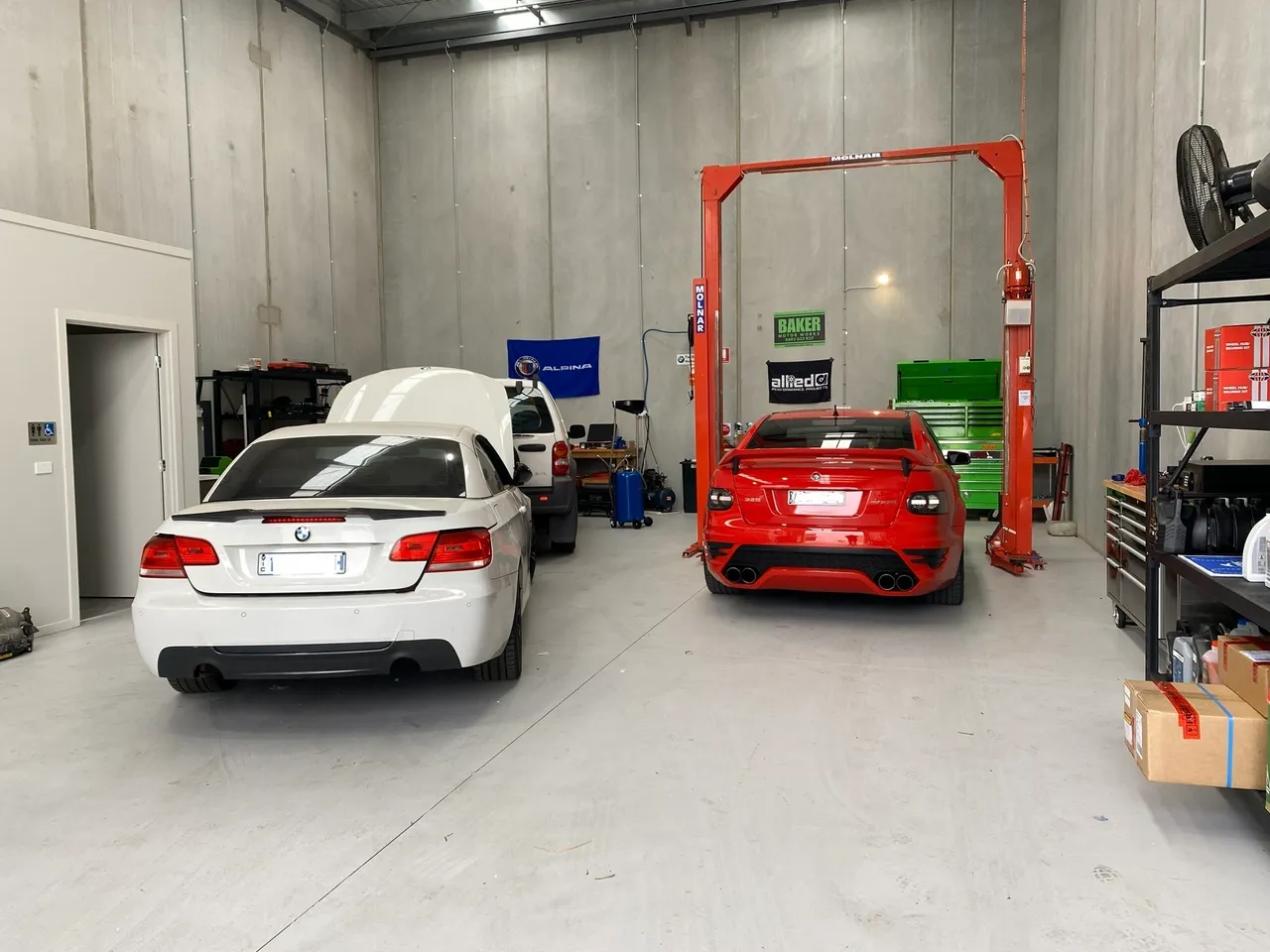 Clean workshop bay with European performance cars